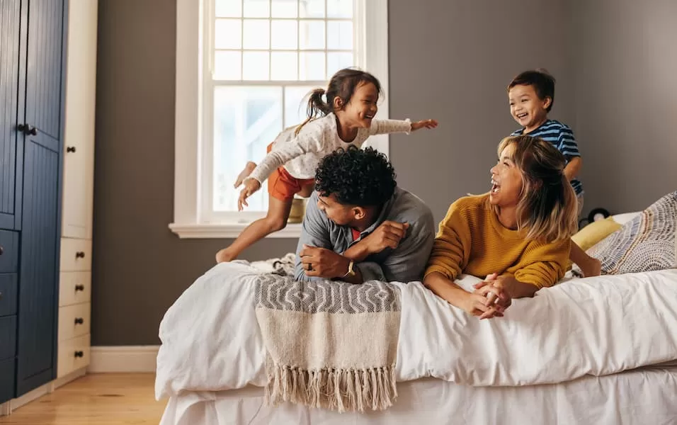Happy family laughing together on the bed