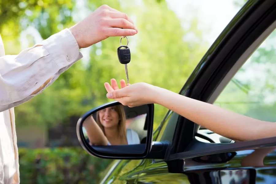 A young driver grabs the keys to a vehicle she financed with a credit union low-credit auto loan.