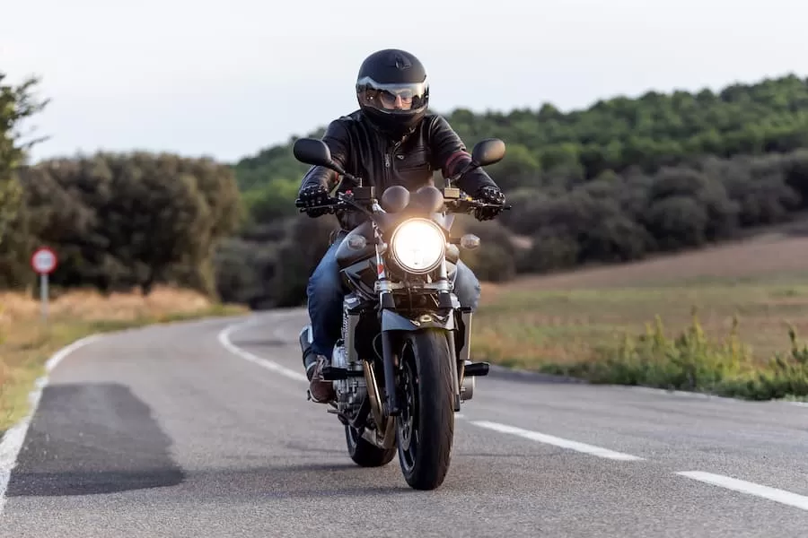 A man rides the motorcycle he financed through a credit union.